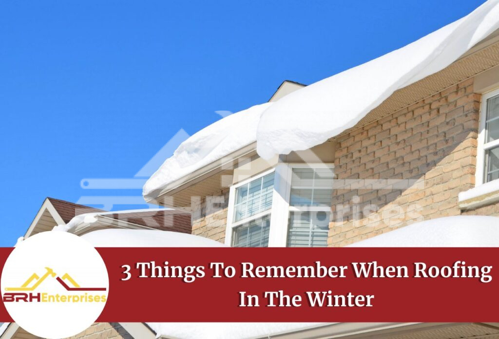 Snow-covered house roof with brick exterior against blue sky for winter roofing tips