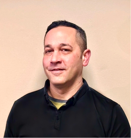 Smiling man in black polo shirt against beige wall background portrait photo