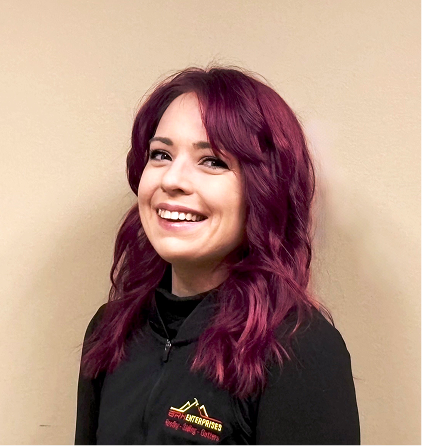 Young woman with vibrant burgundy hair smiling against neutral background
