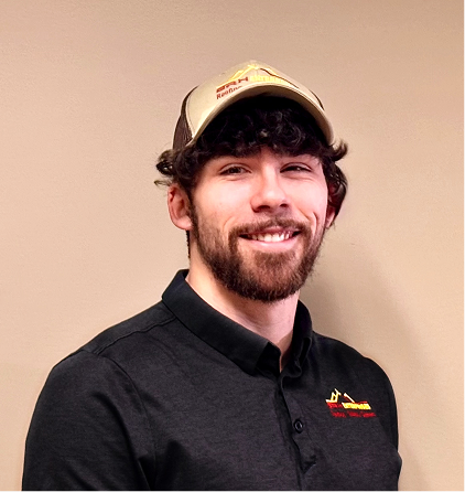 Smiling bearded man in black polo shirt and baseball cap against beige background