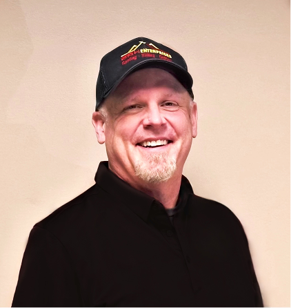 Smiling man wearing black baseball cap and hoodie against neutral background