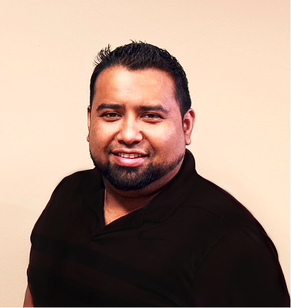 Professional headshot of smiling man with beard wearing black shirt against light background
