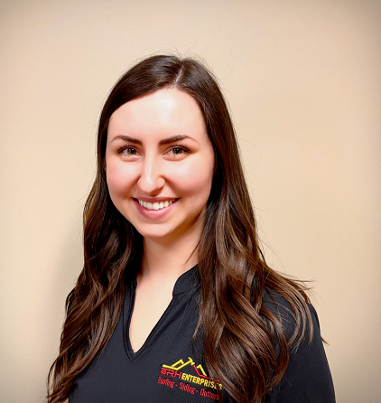 Smiling woman with long hair in a black shirt against a beige background.