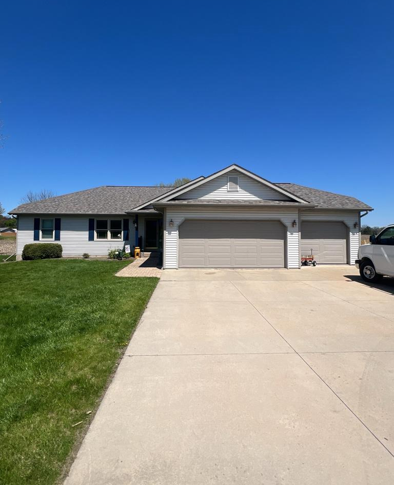 Single-story suburban house with attached garage and green lawn