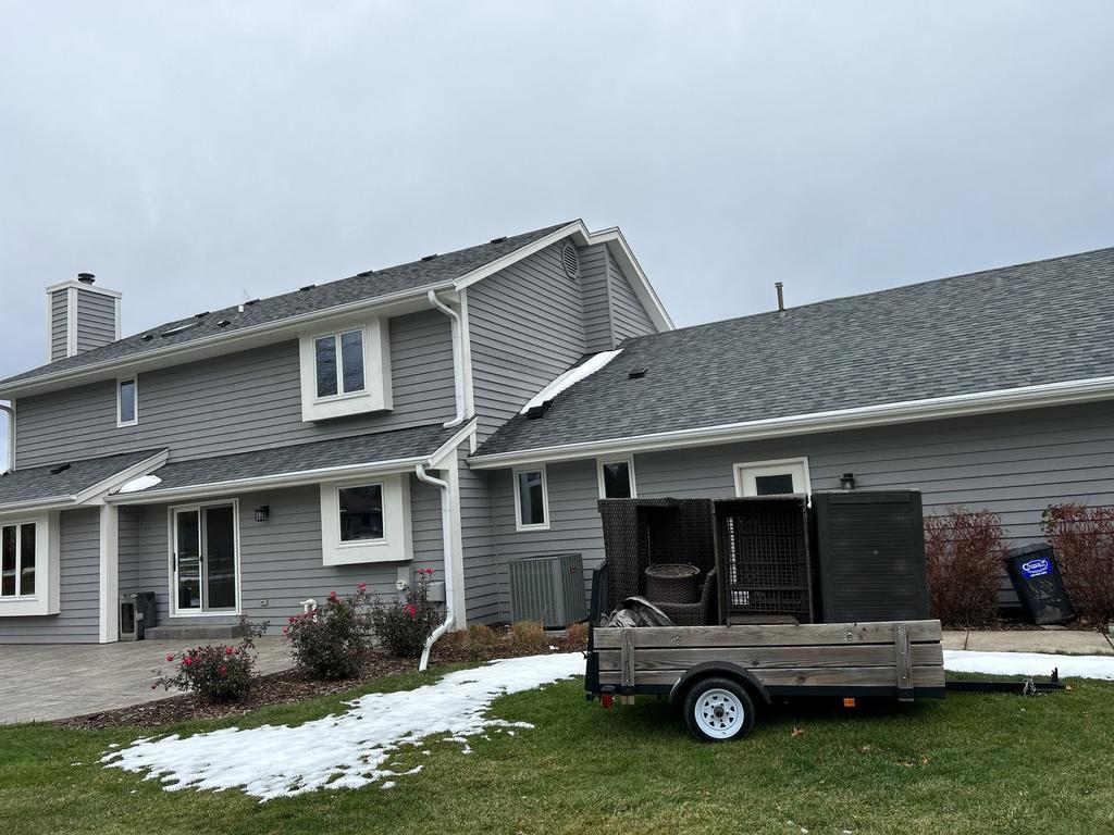 Suburban home with trailer in front yard, overcast sky