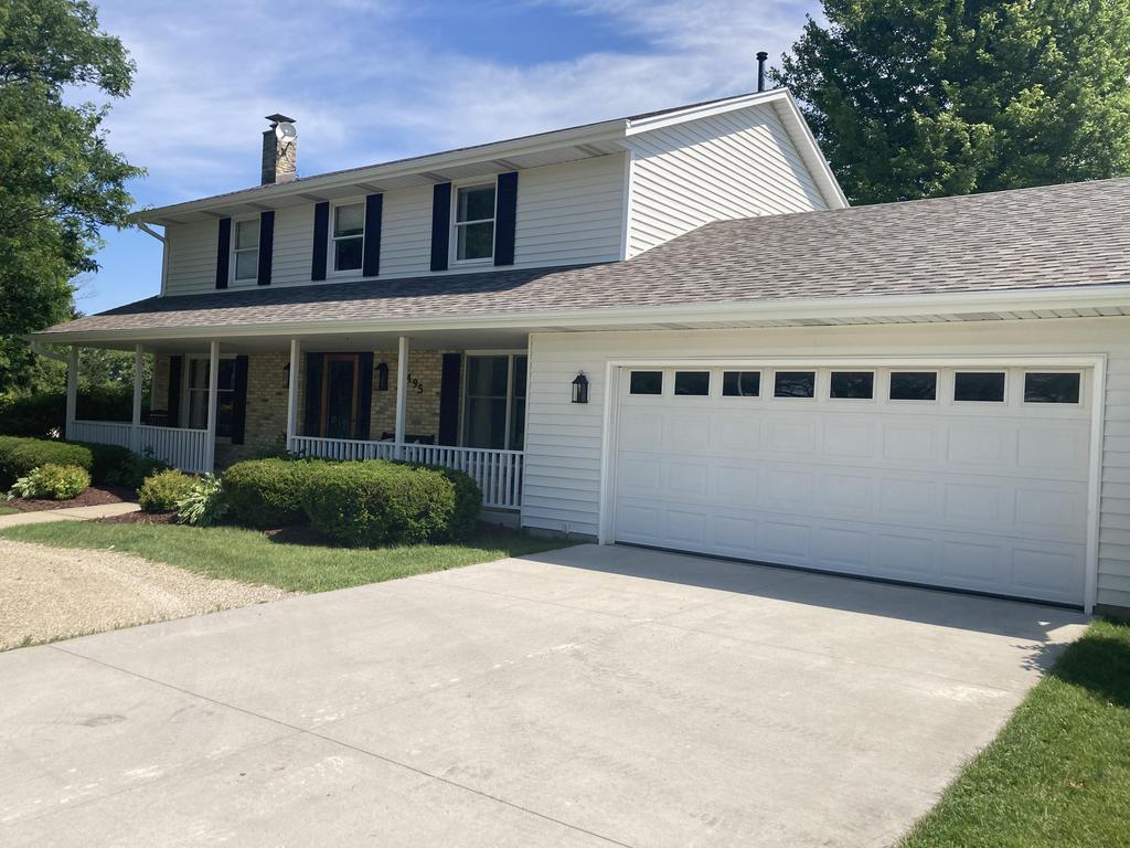 Charming two-story house with white siding and a large garage.