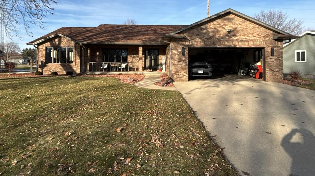 Charming brick suburban home with open garage and spacious lawn