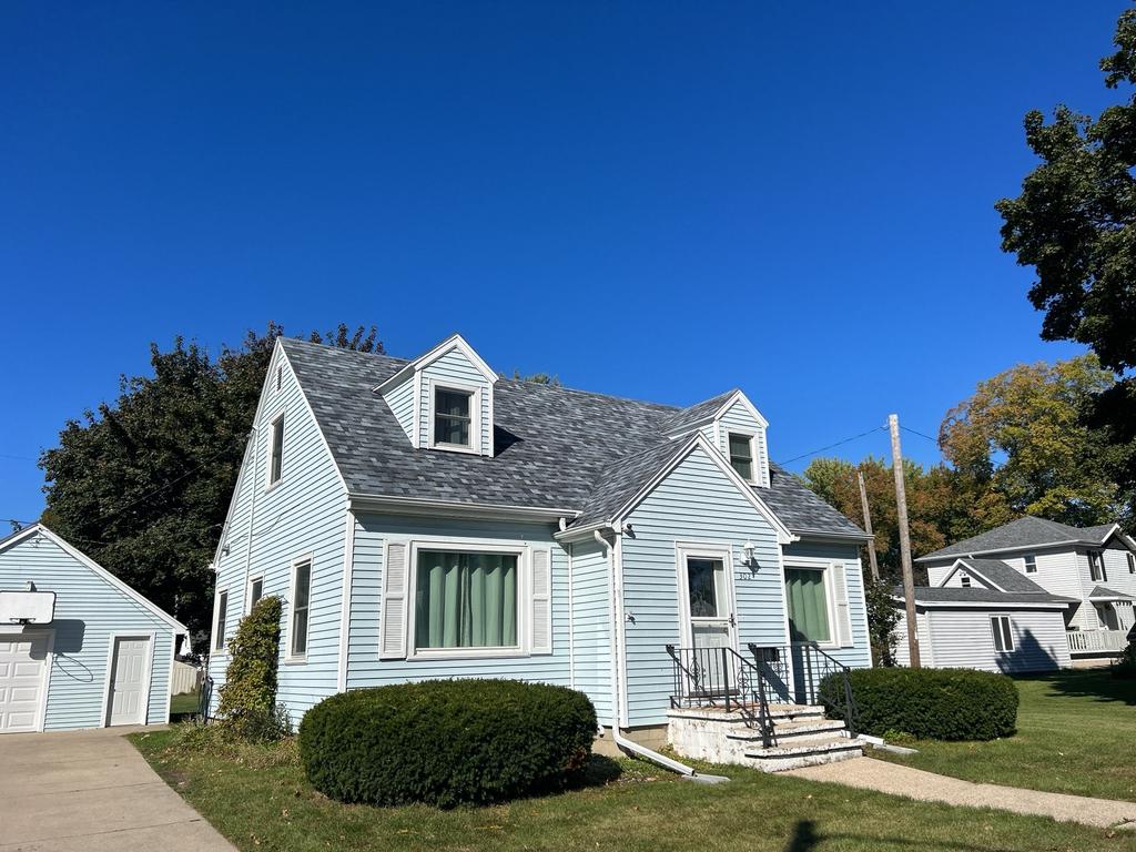 Charming blue house with gable roof under clear sky